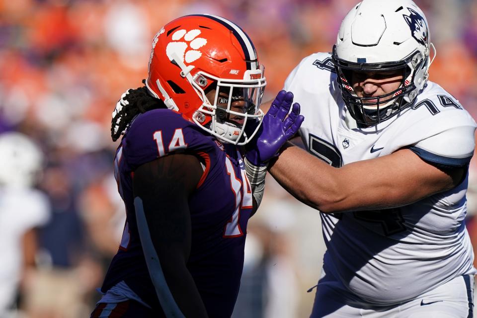 Clemson defensive end Kevin Swint (14) and Connecticut offensive lineman Ryan Van Demark (74) in the second half of an NCAA college football game, Saturday, Nov. 13, 2021, in Clemson, S.C. (AP Photo/Brynn Anderson)