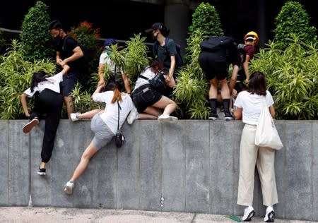 People and protesters run away from the riot police outside the terminals at Hong Kong International Airport