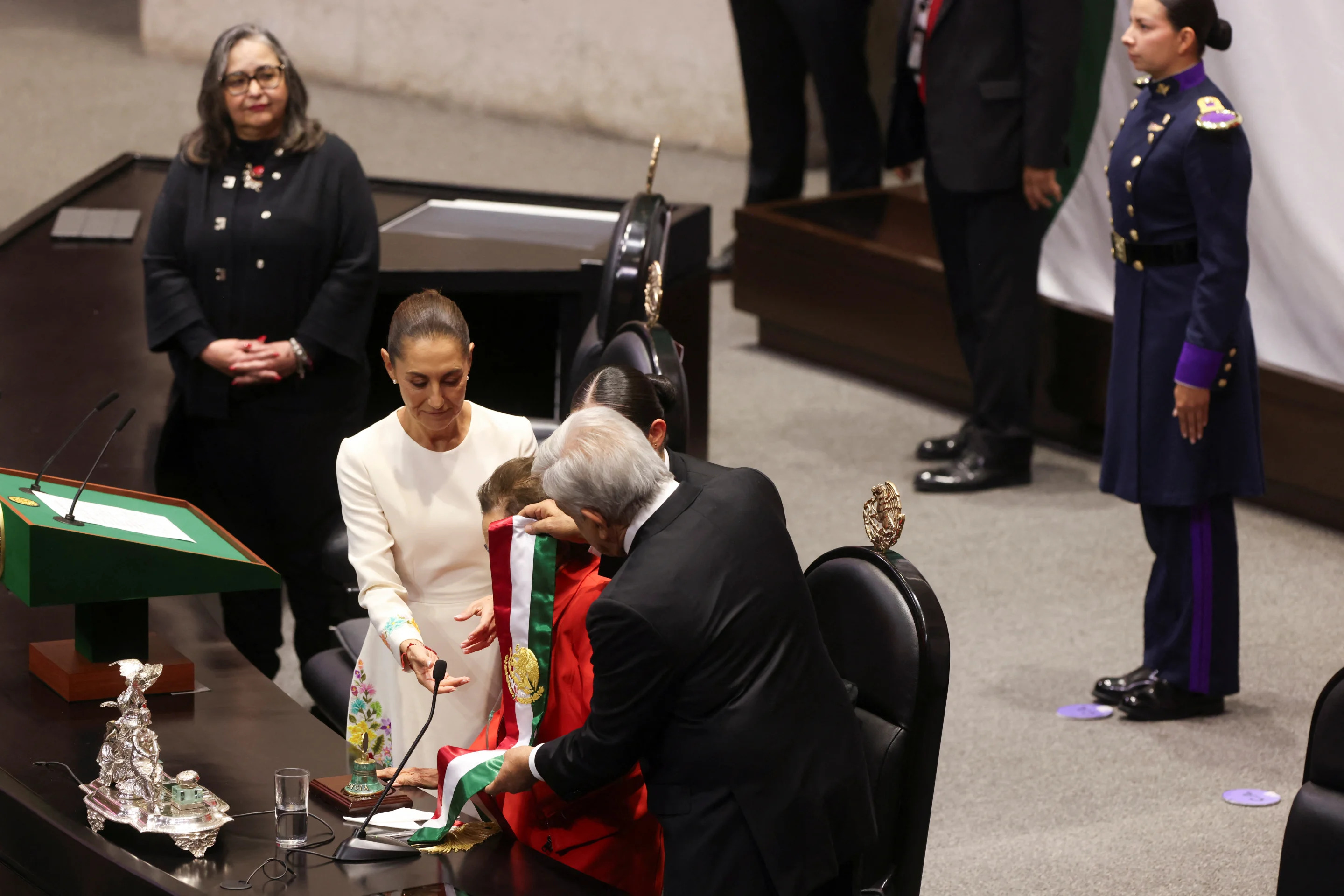 Andres Manuel Lopez Obrador hands the sash during Mexico's new President Claudia Sheinbaum's swearing in ceremony as President of the Supreme Court of Justice of Mexico Norma Pina looks on, at the Congress, in Mexico City, Mexico October 1, 2024. REUTERS/Quetzalli Nicte-Ha