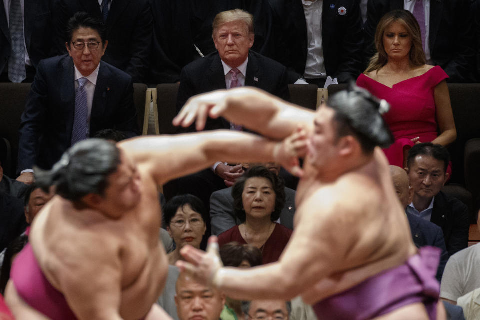 President Donald Trump attends the Tokyo Grand Sumo Tournament with Japanese Prime Minister Shinzo Abe at Ryogoku Kokugikan Stadium, Sunday, May 26, 2019, in Tokyo. First lady Melania Trump is at top right. (AP Photo/Evan Vucci)