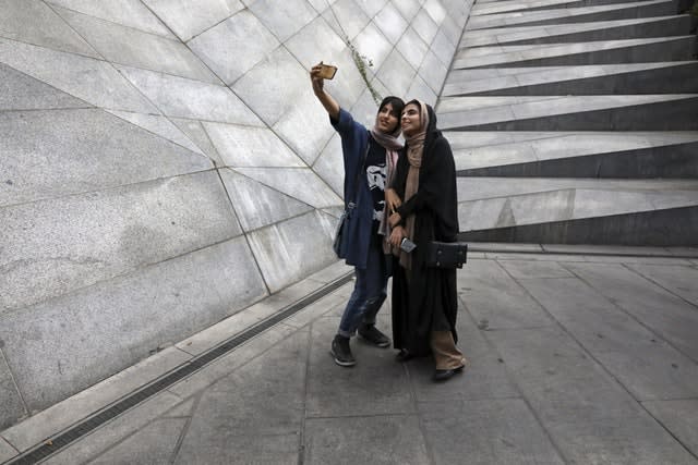 Two Iranian women take a selfie outside a shopping centre in northern Tehran