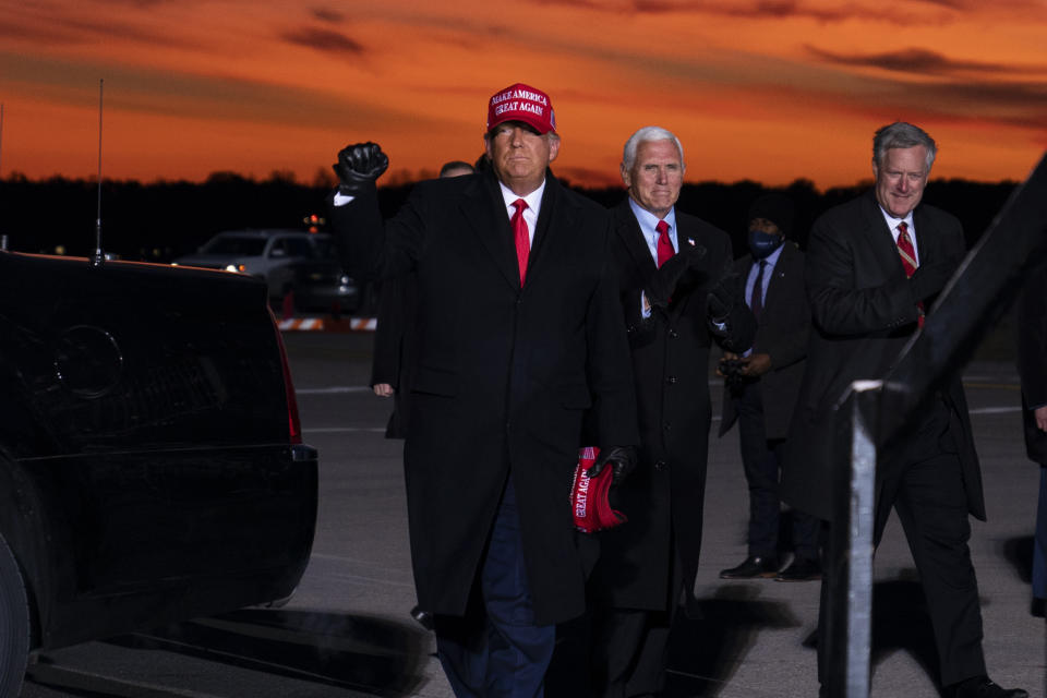 President Donald Trump and Vice President Mike Pence arrive for a campaign rally at Cherry Capital Airport, Monday, Nov. 2, 2020, in Traverse City, Mich. At right is White House chief of staff Mark Meadows. (AP Photo/Evan Vucci)