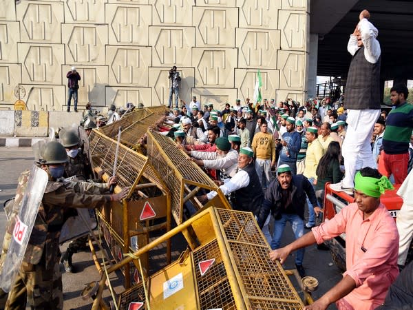  Members of Bhartiya Kisan Union try to remove the barricades as they protest at the Delhi-Gaziabad border, in New Delhi on Sunday. (Photo/ANI)