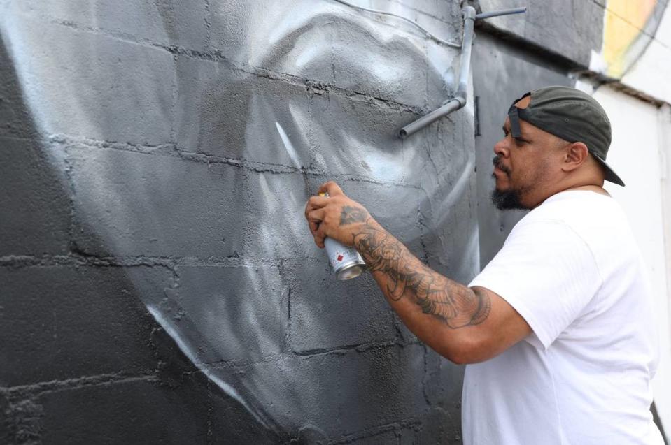 Kevin “Scene” Lewis touches up his mural of civil rights leader John Lewis on Monday, June 24, 2024, off of South Commercial Circle in Warner Robbins, Georgia. Lewis repainted parts of the mural after it was defaced on Friday.