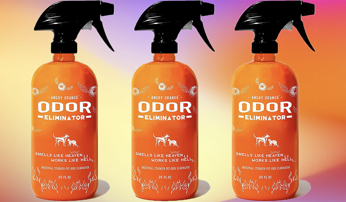 Three orange bottles of odor eliminator lined up, each with a black spray nozzle. 