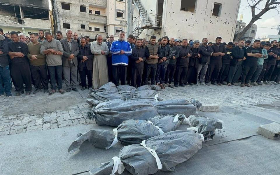 Dead bodies of three sons of Hamas leader Ismail Haniyeh, along with of his two grandchildren, are seen on the ground as people perform funeral prayers in Gaza City