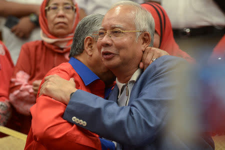 Ousted Malaysian Prime Minister Najib Razak (R) is hugged by Ahmad Zahid Hamid, former deputy prime minister, during a news conference in Kuala Lumpur, Malaysia May 12, 2018. REUTERS/Stringer