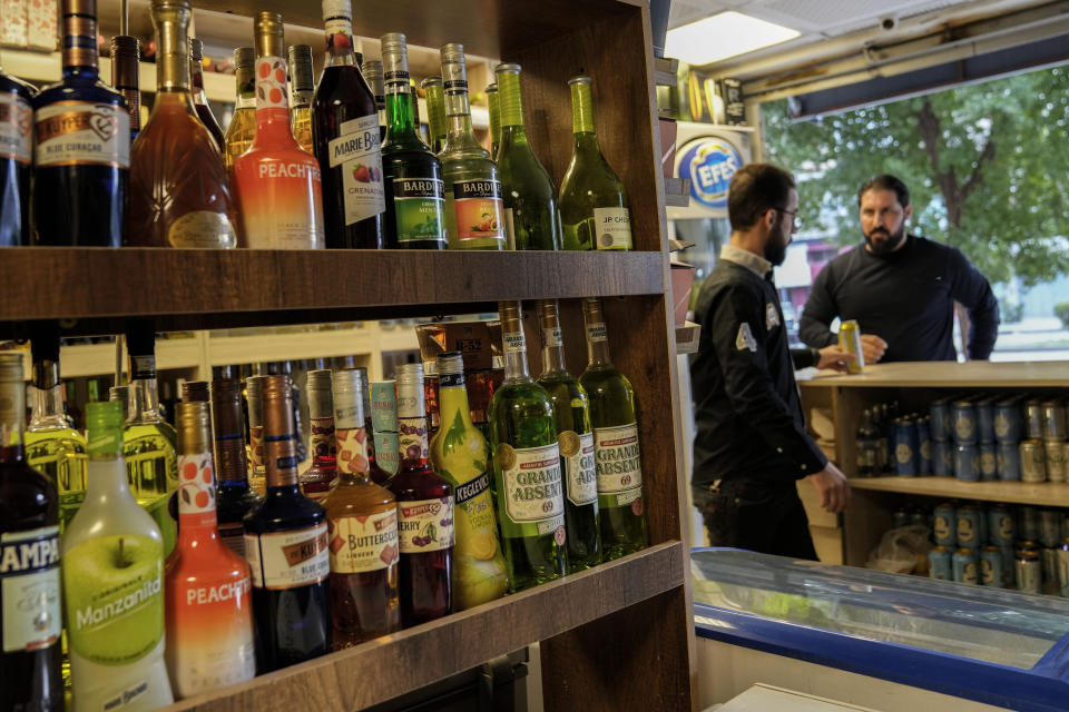 People buy alcohol in a liquor store in Baghdad, Iraq, Thursday, March 9, 2023. The Iraqi government started enforcing a 2016 ban on alcoholic beverages this month, although many liquor shops remained open in Baghdad. (AP Photo/Hadi Mizban)