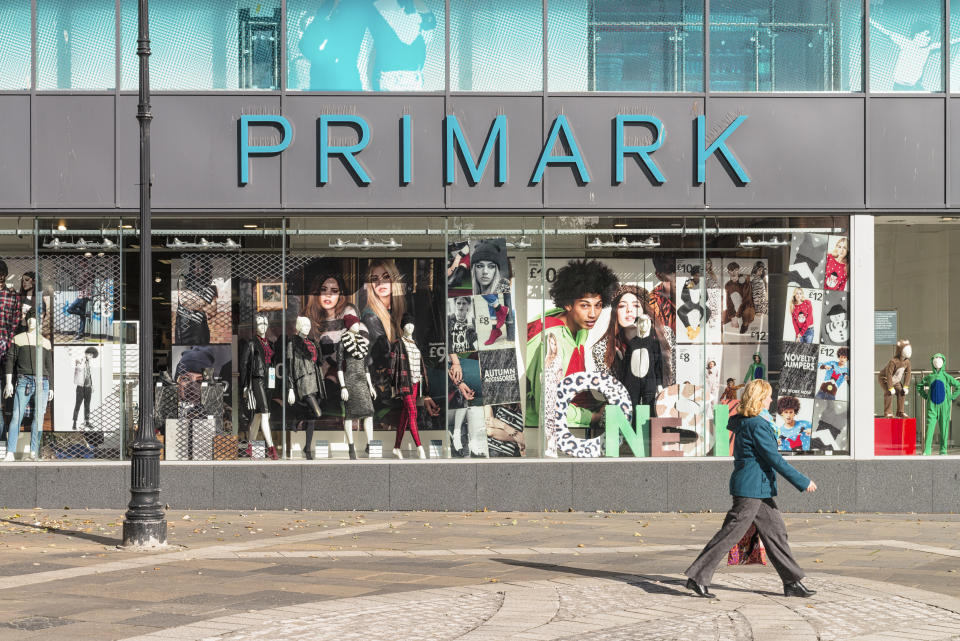 Dundee, UK - October 10, 2013: A woman walking past a window display for the Primark at the Overgate shopping centre in central Dundee.