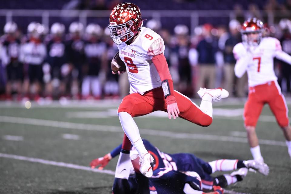 Sweetwater quarterback Leo Holsey (9) leaps over a defender during a run in the Region I-4A Division II area playoff against Aubrey on Nov. 19, 2021, at Tarleton Memorial Stadium in Stephenville.