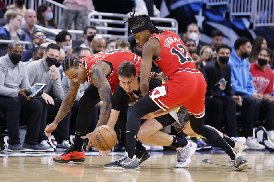 Orlando Magic forward Franz Wagner (22) battles Chicago Bulls forward DeMar DeRozan, left, and guard Ayo Dosunmu (12) for the ball in the first half of an NBA basketball game, Sunday, Jan. 23, 2022, in Orlando, Fla. (AP Photo/Joe Skipper)