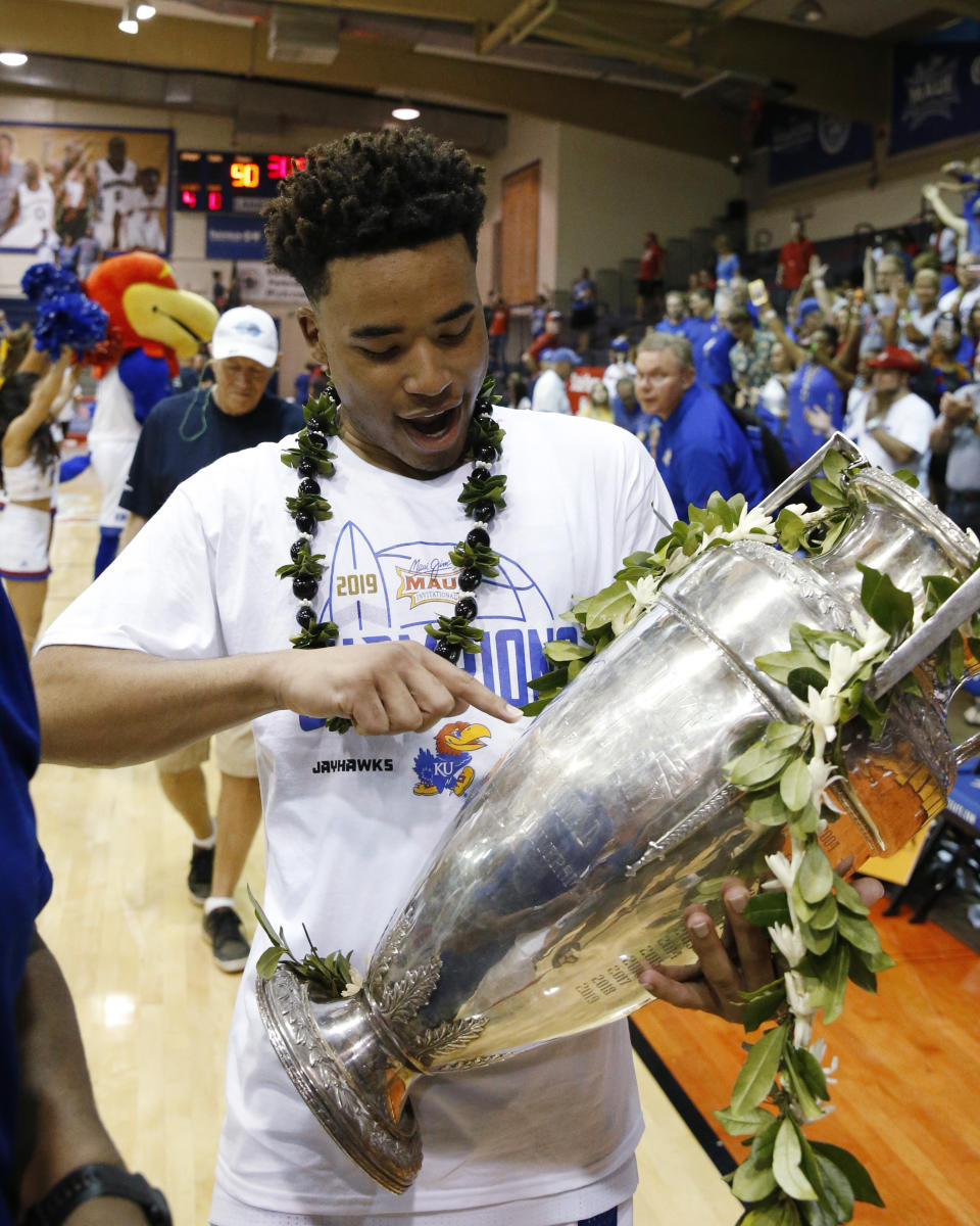 Kansas guard Devon Dotson holds the Maui Invitational trophy Wednesday, Nov. 27, 2019, in Lahaina, Hawaii. Kansas defeated Dayton in 90-84 in overtime in an NCAA college basketball game for the title. (AP Photo/Marco Garcia)