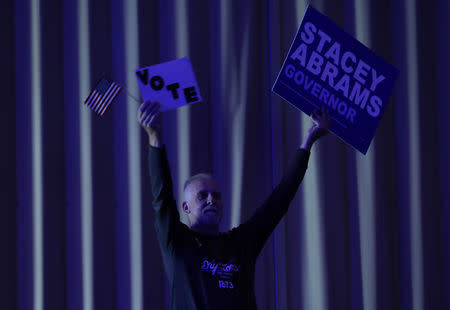 A supporter of Stacey Abrams holds up a voting sign and an American flag as Stacey Abrams, the Democratic gubernatorial candidate for Georgia, speaks to a crowd in Columbus, Georgia, U.S., ahead of the midterm elections, October 25, 2018. REUTERS/Lawrence Bryant