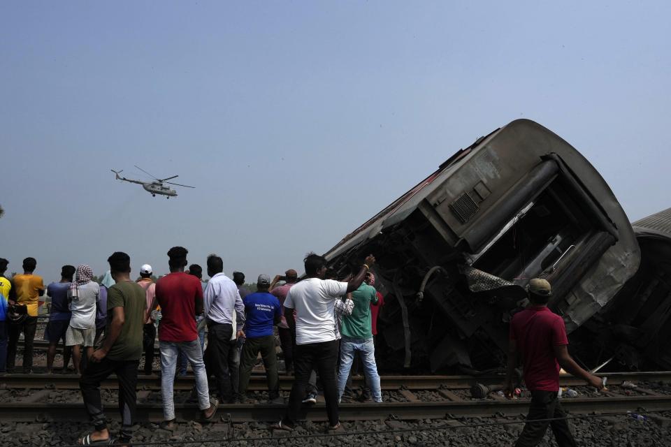 A chopper flies over the site of passenger trains that derailed in Balasore district, in the eastern Indian state of Orissa, Saturday, June 3, 2023. Rescuers are wading through piles of debris and wreckage to pull out bodies and free people after two passenger trains derailed in India, killing more than 280 people and injuring hundreds as rail cars were flipped over and mangled in one of the country’s deadliest train crashes in decades. (AP Photo/Rafiq Maqbool)