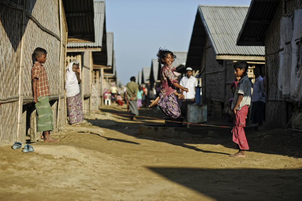 In this Nov. 30 2013 photo, Tawhera Begum, sister of Senwara, jumps as she plays with friends at the Ohn Taw refugee camp on the outskirts of Sittwe, Myanmar. Their tiny Muslim village in Myanmar's northwest Rakhine had been destroyed in a fire set by an angry Buddhist mob. (AP Photo/Kaung Htet)