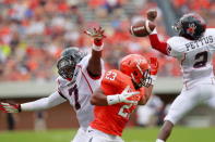 Running back Khalek Shepherd #23 of the Virginia Cavaliers, defensive back DeShawn Holmes #7 of the Richmond Spiders, and defensive back Wayne Pettus #2 of the Spiders reach for the ball at Scott Stadium on September 1, 2012 in Charlottesville, Virginia. (Photo by Geoff Burke/Getty Images)