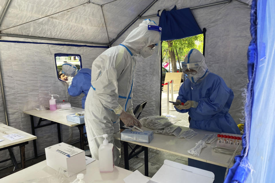 Workers in protective overalls conduct mass COVID testing for residents on Wednesday, May 11, 2022, in Beijing. (AP Photo/Ng Han Guan)