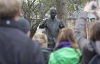 Crowds gather by a statue of former South African President Nelson Mandela in Parliament Square in central London December 15, 2013. South Africa buried Nelson Mandela on Sunday, closing one chapter in its tortured history and opening another in which the multi-racial democracy he founded will have to discover if it can thrive without its central pillar. REUTERS/Neil Hall (BRITAIN - Tags: POLITICS SOCIETY)