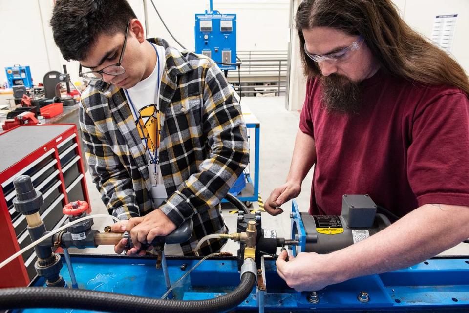 Damian Suarez, left, and Dino Brochini install a pump at the VOLT Institute in Modesto, Calif., on Thursday, March. 5, 2020. Both men are students in the industrial maintenance mechanic program.