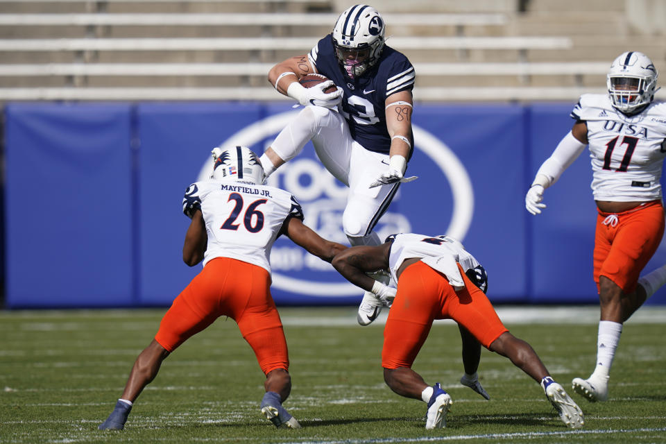 BYU tight end Masen Wake (13) hurdles UTSA's Corey Mayfield Jr. (26) and Antonio Parks in the first half during an NCAA college football game Saturday, Oct. 10, 2020, in Provo, Utah. (AP Photo/Rick Bowmer, Pool)