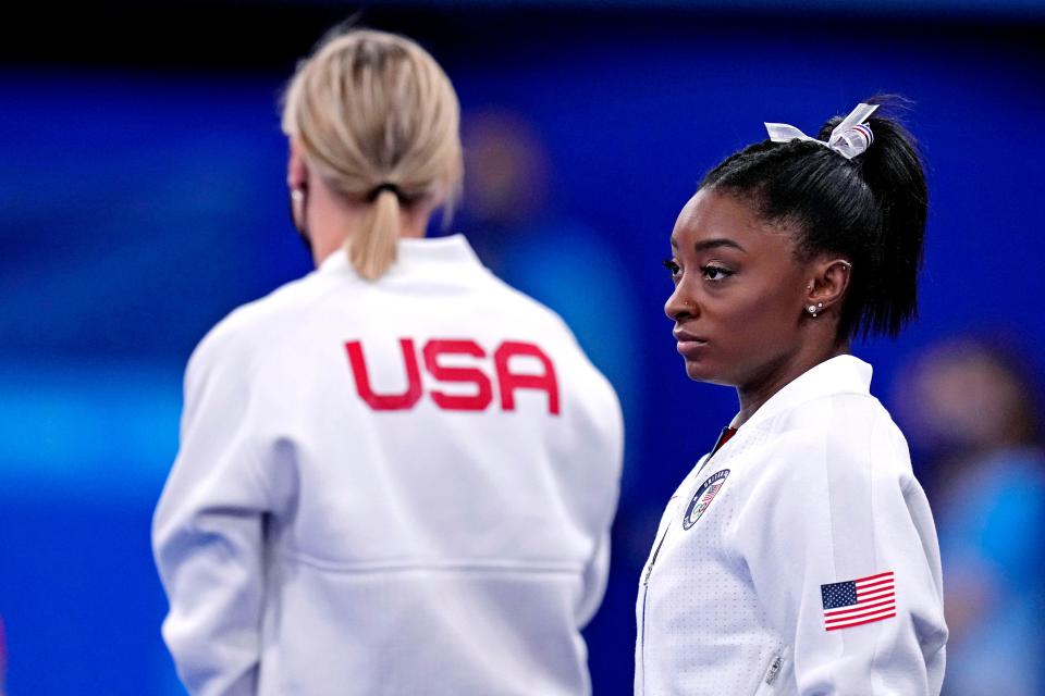 Simone Biles watches her teammates after competing on the vault and then withdrawing from the remaining events.