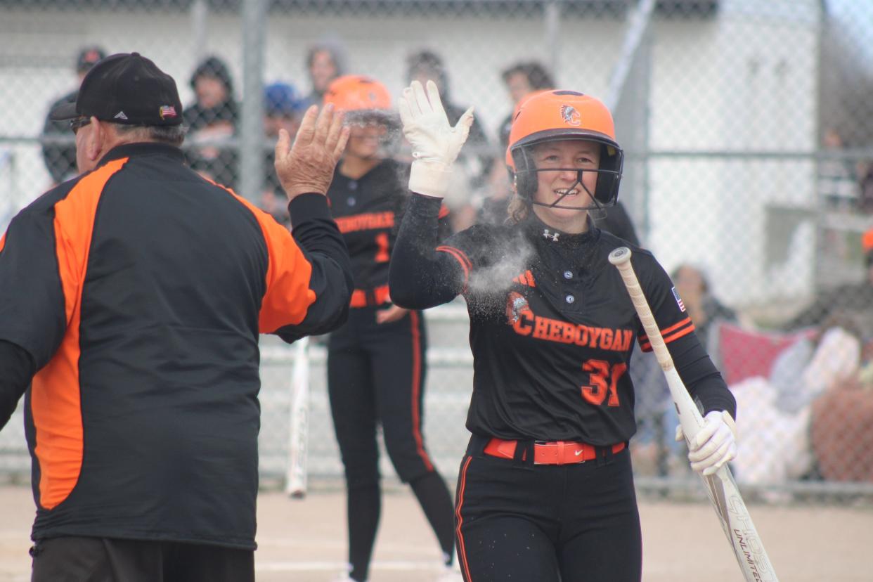 Cheboygan senior Emily Clark gets a high-five from coach Mike LaLonde after scoring a run during game one of Tuesday's softball doubleheader against Boyne City.