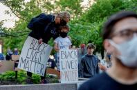 Una mujer y su hijo participan en la manifestación de este 28 de mayo a las puertas del Centro de Gobierno de Minneapolis con un cartel que dice: “La vida de los negros importa”. (Foto: Eric Miller / Reuters).