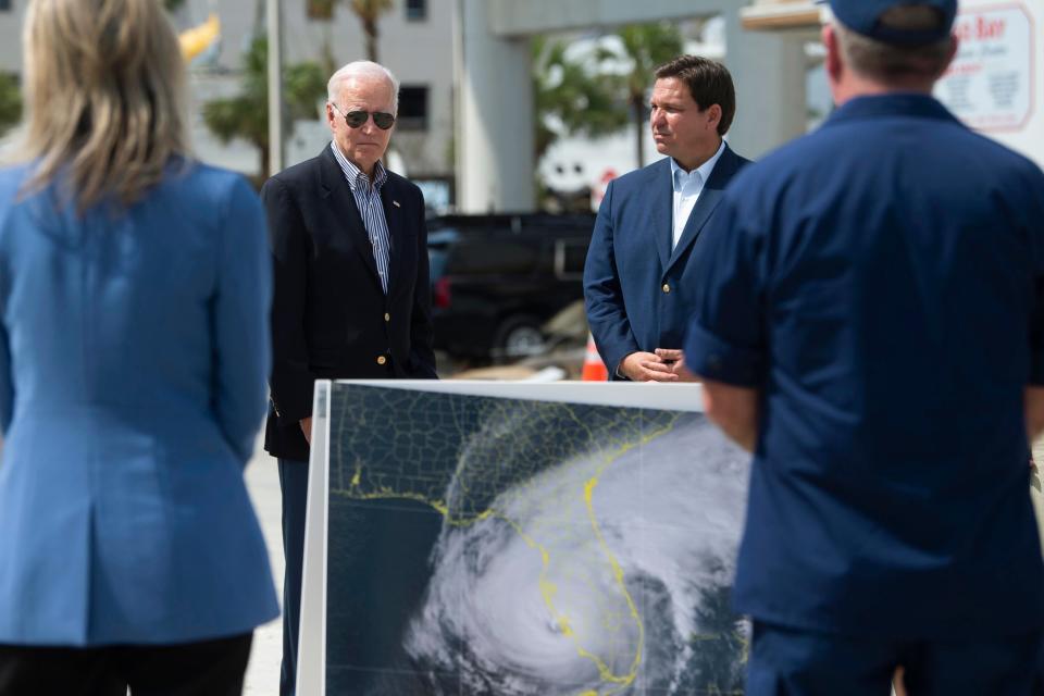 President Joe Biden, left, and Florida Gov. Ron DeSantis, right, meet with residents and emergency workers during a visit to Fisherman's Wharf at Fort Myers Beach, Fla., Wednesday, Oct. 5, 2022, to see the damage caused by Hurricane Ian.