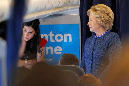 U.S. Democratic presidential nominee Hillary Clinton talks to staff members, including aide Huma Abedin (L), onboard her campaign plane in White Plains, New York, U.S. October 28, 2016. REUTERS/Brian Snyder