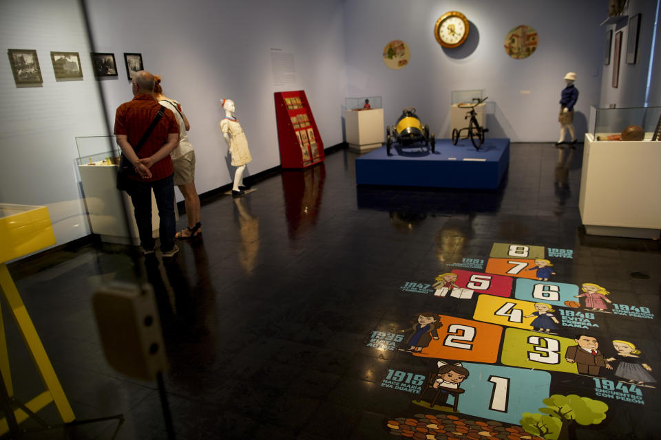 People visit the "Childhood and Peronism, the toys of the Eva Perón Foundation" exhibit at the Evita Museum in Buenos Aires, Argentina Wednesday, April 17, 2019. Detractors of Peronism accuse the movement of engaging in populism and clientelism to win votes from the poor rather than promoting social mobility through enduring structural reforms. But away from political debates, Evita's figure has transcended time and borders. (AP Photo/Natacha Pisarenko)