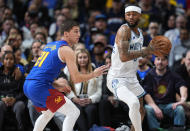 Minnesota Timberwolves guard Nickeil Alexander-Walker, right, looks to pass the ball as Denver Nuggets guard Collin Gillespie defends in the first half of an NBA basketball game Friday, March 29, 2024, in Denver. (AP Photo/David Zalubowski)