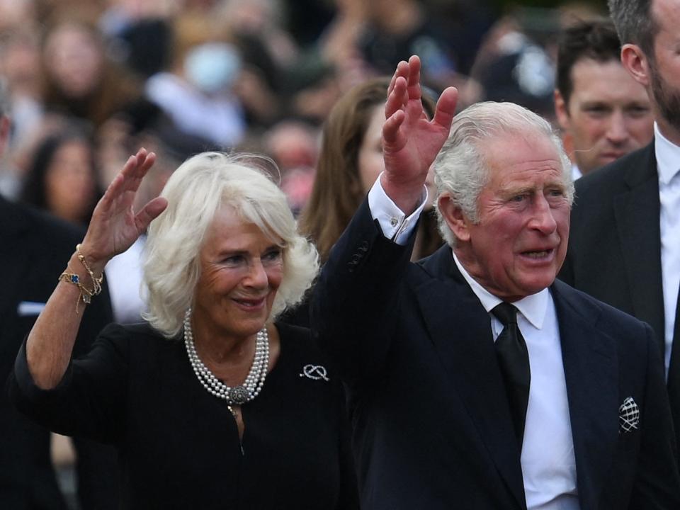 King Charles and Queen Consort Camilla wave to the public as they arrive at Buckingham palace on September 9, 2022.