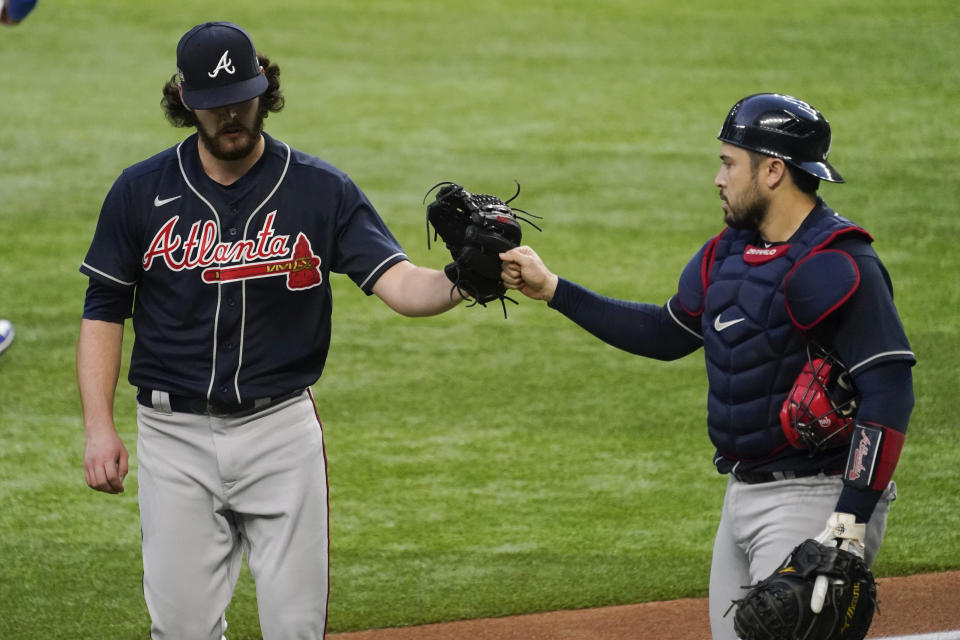 Atlanta Braves starting pitcher Ian Anderson and catcher Travis d'Arnaud celebrate the end of the fourth inning in Game 2 of a baseball National League Championship Series against the Los Angeles Dodgers Tuesday, Oct. 13, 2020, in Arlington, Texas. (AP Photo/Tony Gutierrez)