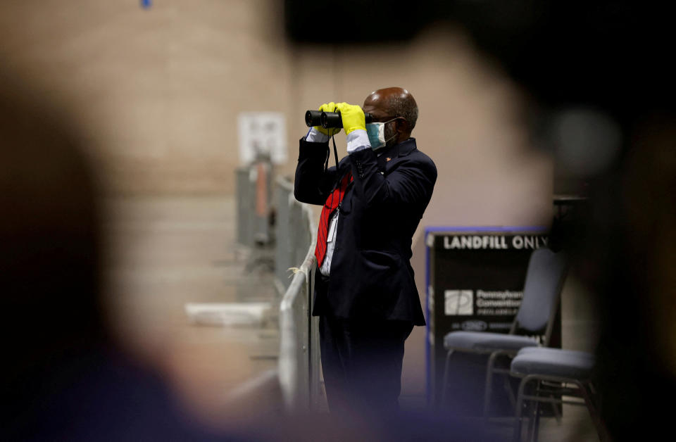 A poll watcher observes through a pair of binoculars as votes are counted at the Pennsylvania Convention Center in Philadelphia, on Nov. 3, 2020.<span class="copyright">Rachel Wisniewski—Reuters</span>