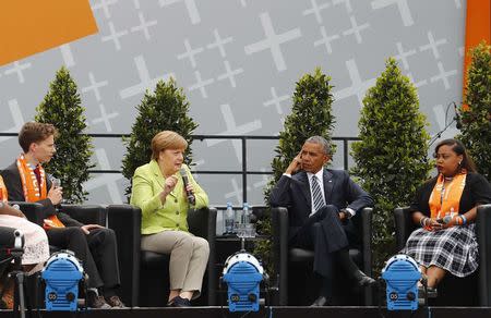 German Chancellor Angela Merkel, and former U.S. President Barack Obama attend a discussion with Benedikt Wichtlhuber and Sierra Sims at the German Protestant Kirchentag in front of the Brandenburg Gate in Berlin, Germany, May 25, 2017. REUTERS/Fabrizio Bensch