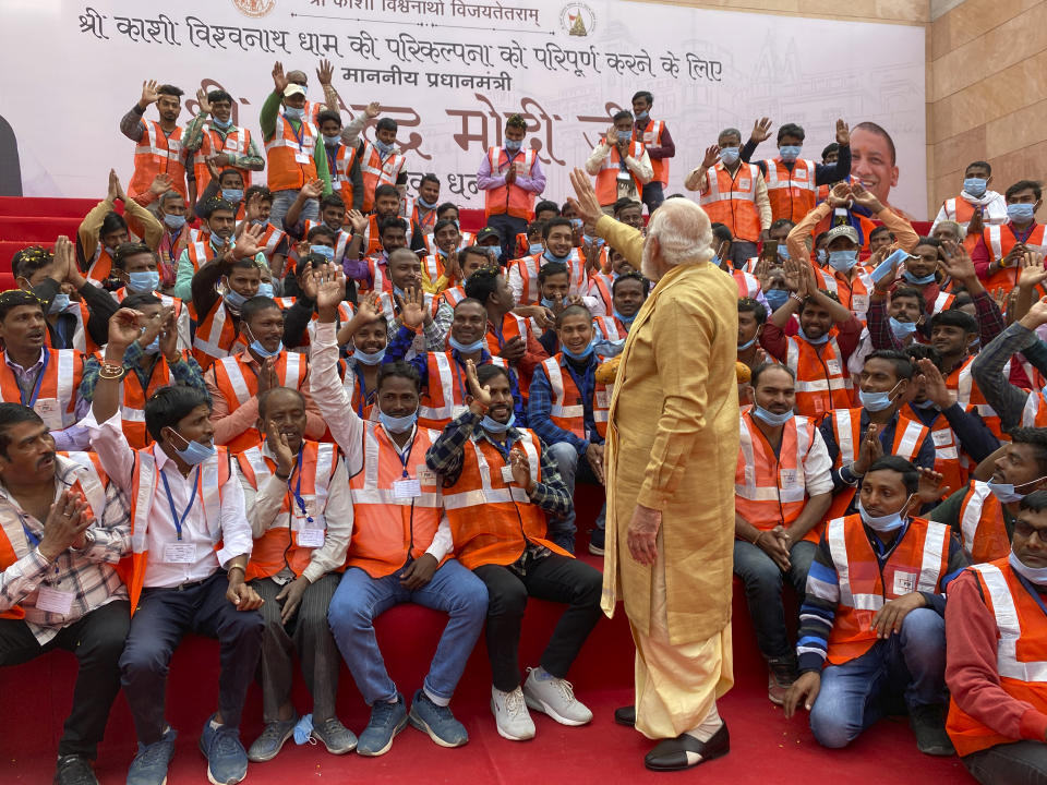 Indian Prime Minister Narendra Modi, center, greets workers during the inauguration of Kashi Vishwanath Dham Corridor, a promenade that connects the sacred Ganges River with the centuries-old temple dedicated to Lord Shiva in Varanasi, India, Monday, Dec. 13, 2021. (AP Photo/Rajesh Kumar Singh)