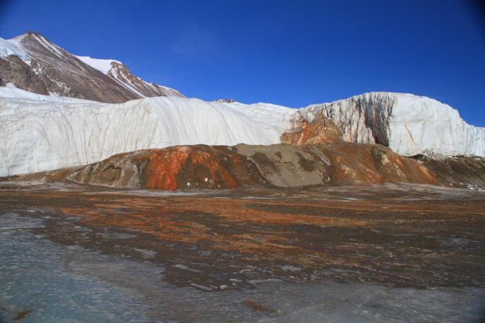 Orange and red water pouring out of glacier