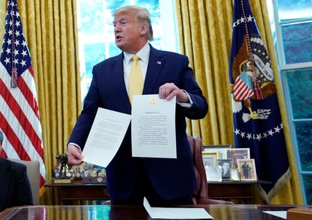 U.S. President Trump holds letter from China's President Xi Jinpingduring meeting with China's Vice Premier Liu at the White House in Washington