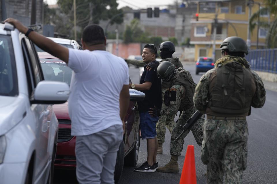 Soldados registran a un conductor en un control de seguridad antes de la segunda vuelta de las elecciones presidenciales en Durán, Ecuador, el viernes 13 de octubre de 2023. (AP Foto/Martín Mejía)