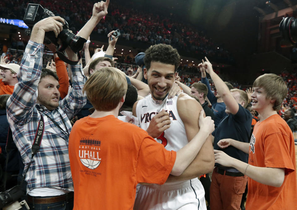 Virginia forward Anthony Gill (13) is mobbed by fans after their win over Syracuse in Charlottesville, Va., Saturday, March 1, 2014. Virginia won the game 75-56. (AP Photo/Steve Helber)