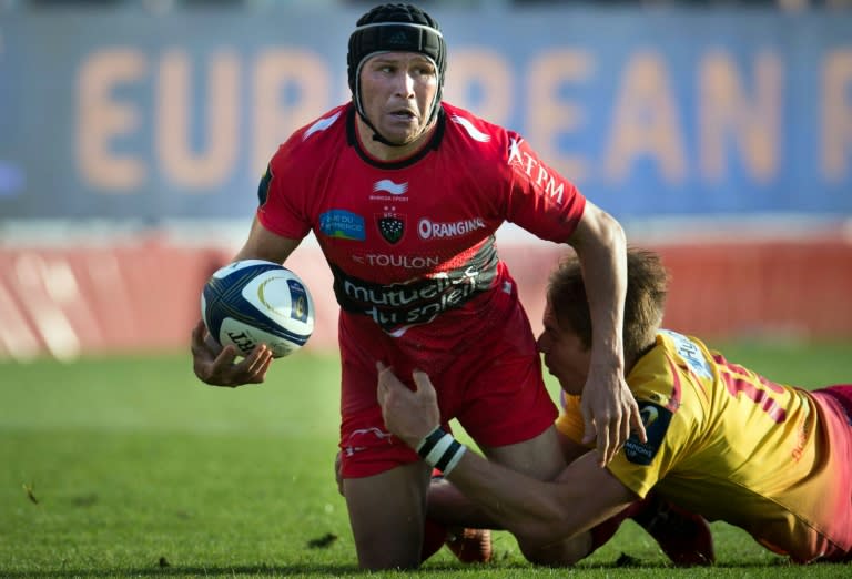 Toulon fly-half Matt Giteau (L) is tackled by Llanelli Scarlets' full-back Liam Williams during the European Champions Cup match at the Mayol stadium in Toulon, southeast France, on October 19, 2014