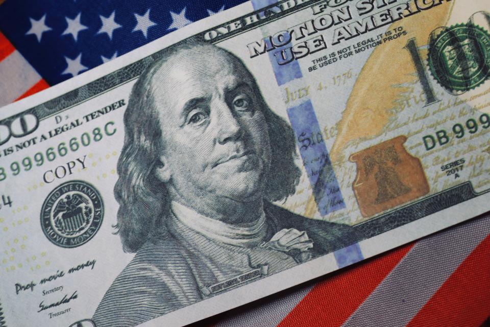 $100 bill with American flag underneath