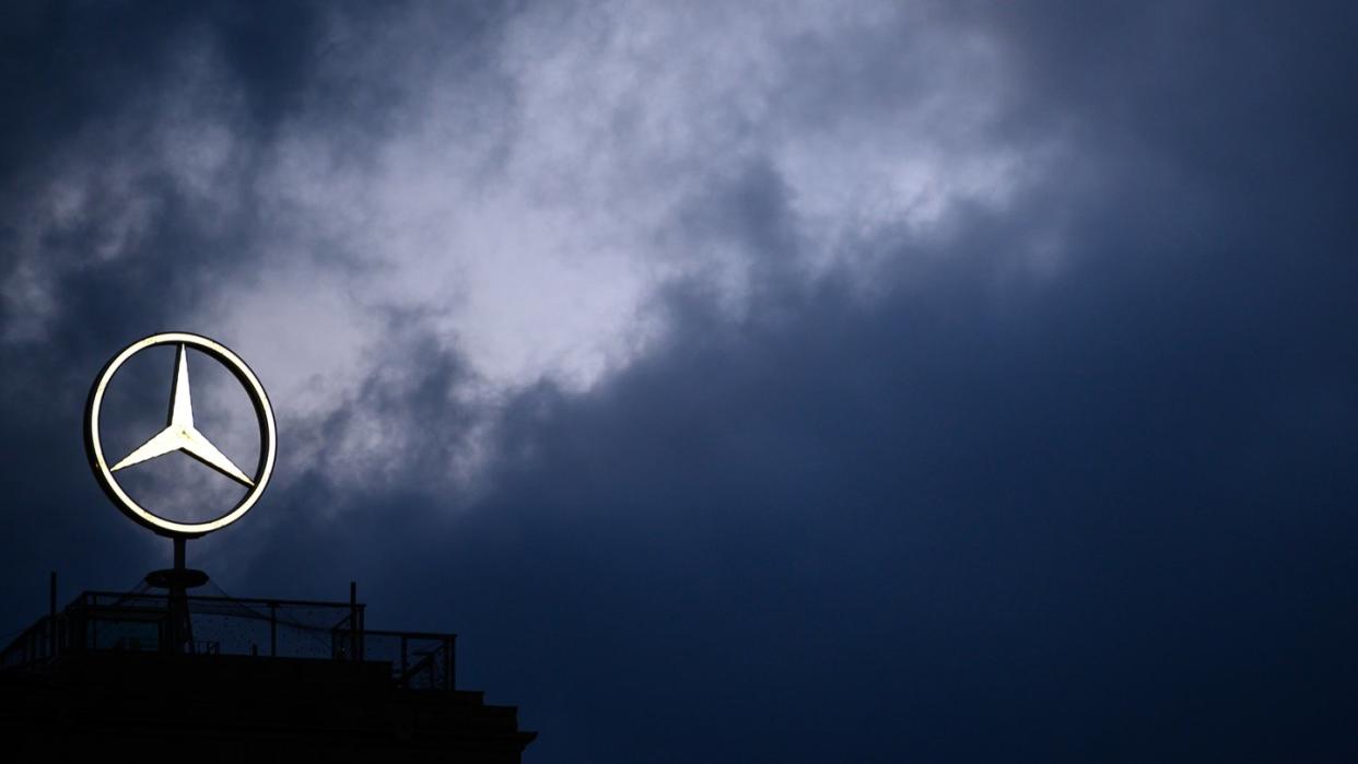 Der Mercedes-Stern vor dem dunklen Himmel.