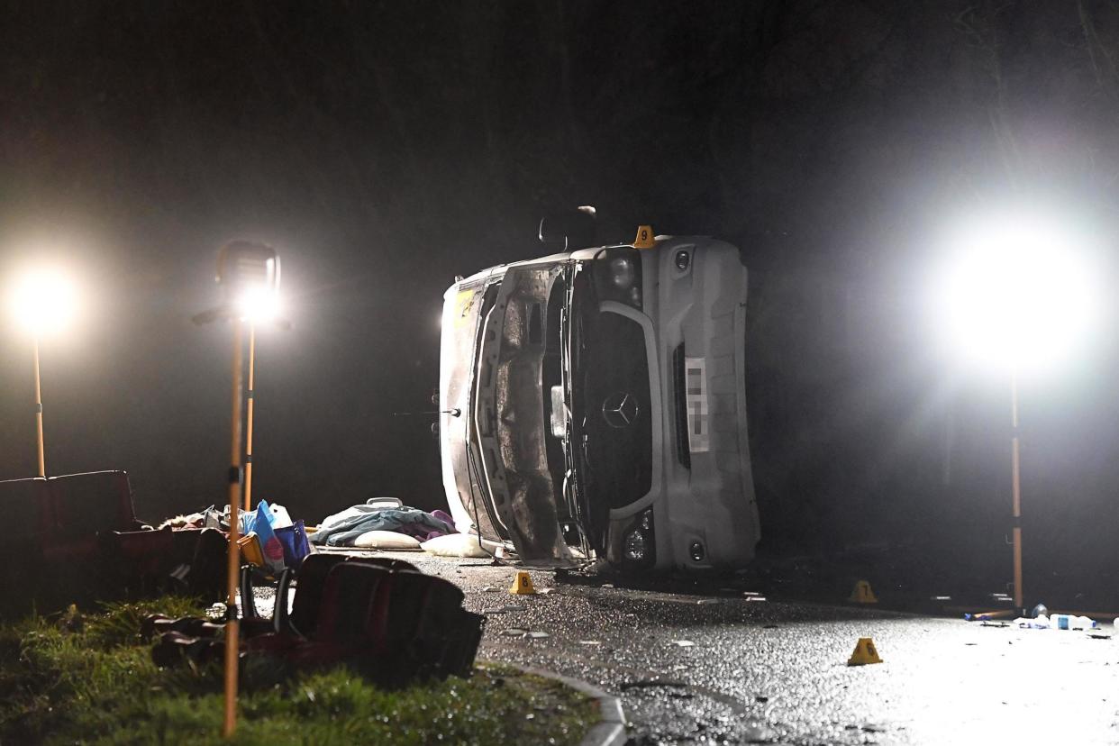 A minibus seen on its side after the serious crash near the village of Bluntisham in Cambridgeshire: PA