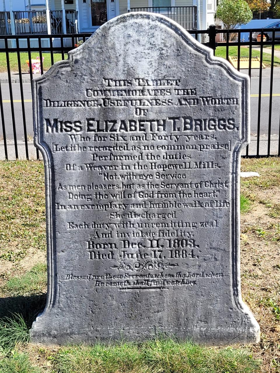 This headstone is a testament to Elizabeth Briggs' 46 years of dedicated work at the Hopewell Mills. It reads in part: "This Tablet Commemorates The Diligence, Usefulness And Worth Of Miss Elizabeth T. Briggs, Who for Six and Forty years, [Let it be recorded as no common praise] Performed the duties Of a Weaver in the Hopewell Mills. .... She discharged Each duty with unremitting zeal And inviolate fidelity."