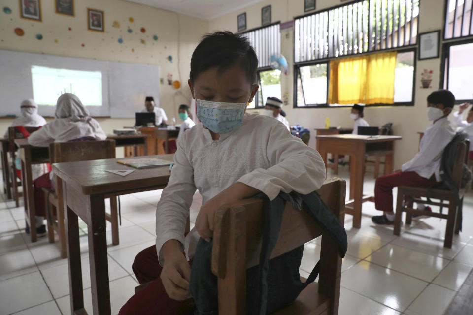 Students wearing face masks sit spaced apart during a trial run of a class with COVID-19 protocols at an elementary school in Jakarta, Indonesia, Friday, June 4, 2021. The world's fourth-most populous country, with about 275 million people, has reported more coronavirus cases than any other Southeast Asian country. (AP Photo/Tatan Syuflana)