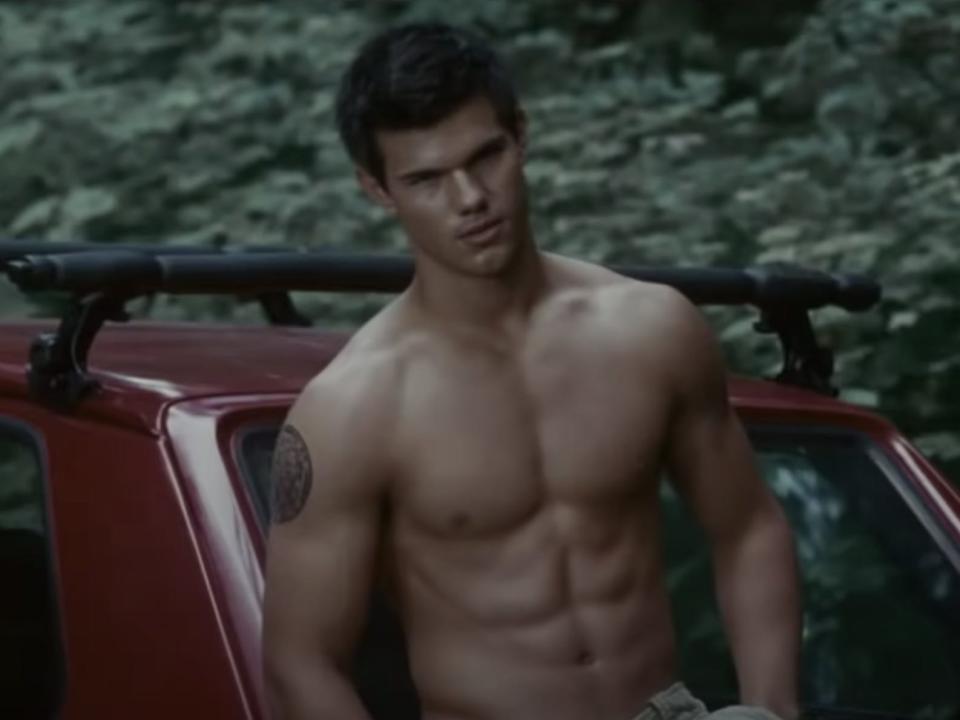 Jacob without a shirt standing by red car in Eclipse