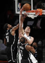 Milwaukee Bucks center Brook Lopez dunks between Brooklyn Nets' Kevin Durant (7) and Kyrie Irving (11) during the second half of Game 1 of an NBA basketball second-round playoff series Saturday, June 5, 2021, in New York. (AP Photo/Adam Hunger)