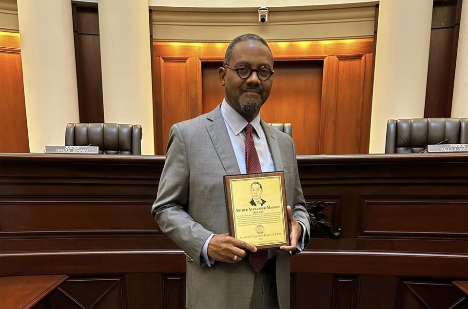 Quinton Seay holds a plaque honoring Arthur Madison, his relative, in the chambers of the Alabama Supreme Court on May 1, 2023. Madison led a voting rights drive in Montgomery in 1944 that led to his arrest and disbarment. Seay says he plans to file actions this summer to posthumously restore Madison’s license.