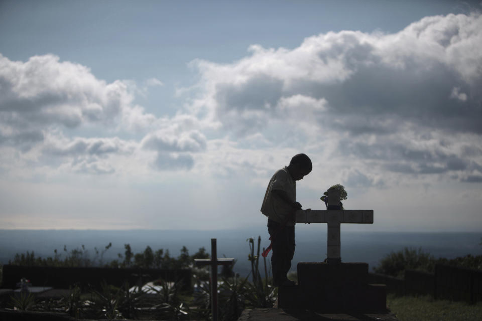 Joel Medrano visits the grave of his father on the Day of the Dead at a cemetery in El Crucero, near of Managua, Nicaragua, Wednesday Nov. 2, 2011. (AP Photo/Esteban Felix)